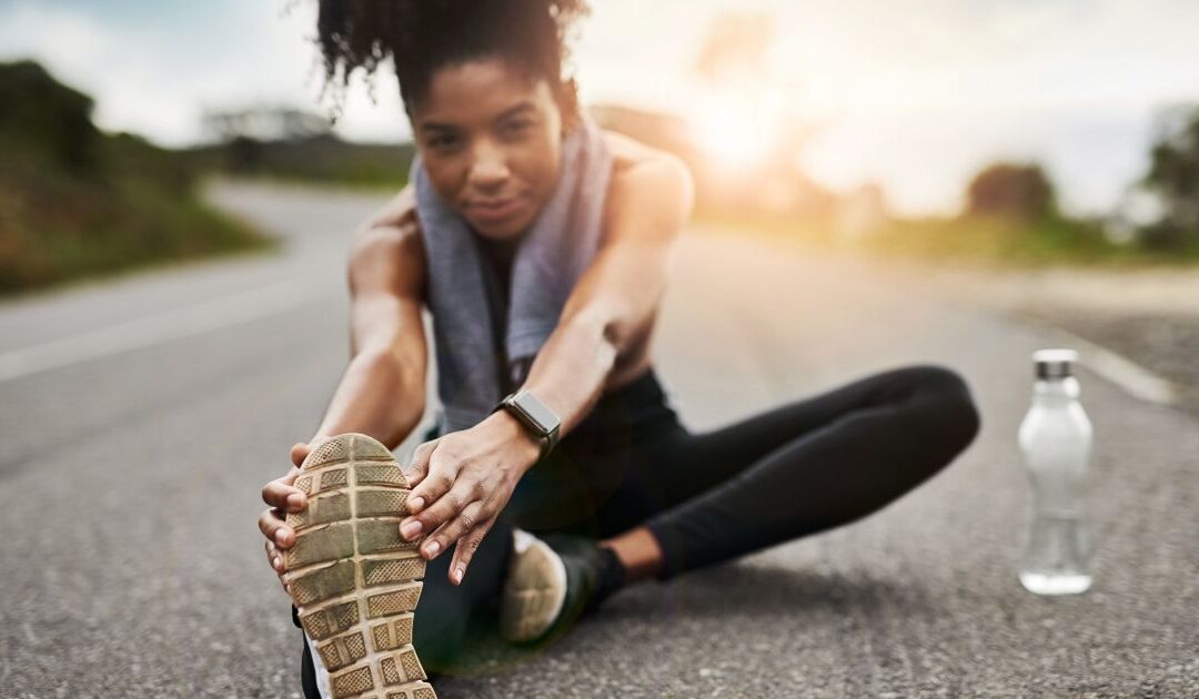Fit woman stretching outdoors, focusing on wellness and recovery, representing the benefits of hyperbaric oxygen therapy for overall health and energy.
