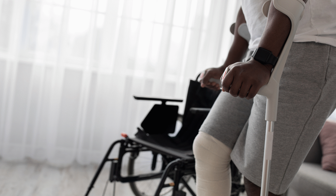 Man recovering from leg surgery using crutches near a wheelchair